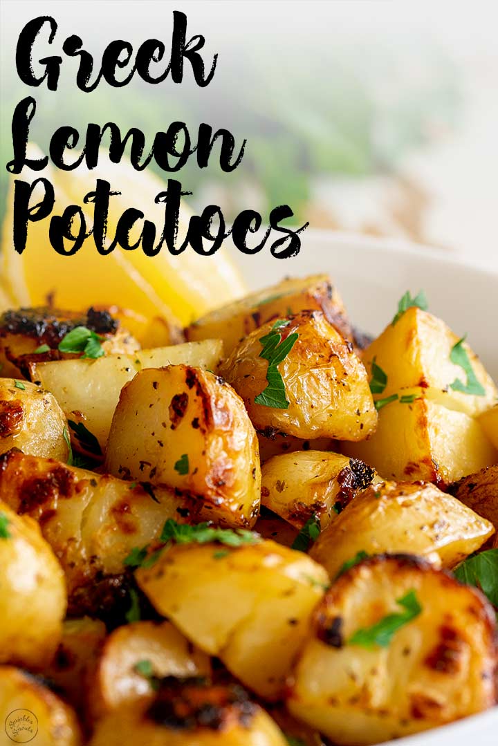 Greek potatoes win a white bowl with lemon wedges and text at the top