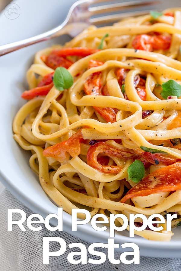 a pale blue bowl of roasted red pepper pasta with text at the bottom