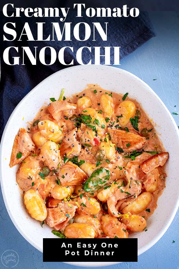 overhead view of a white bowl of creamy tomato gnocchi with text at the top and bottom