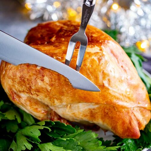 a silver knife carving a Christmas Turkey Crown