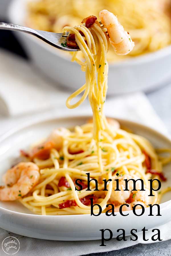a fork lifting up shrimp pasta with text at the bottom