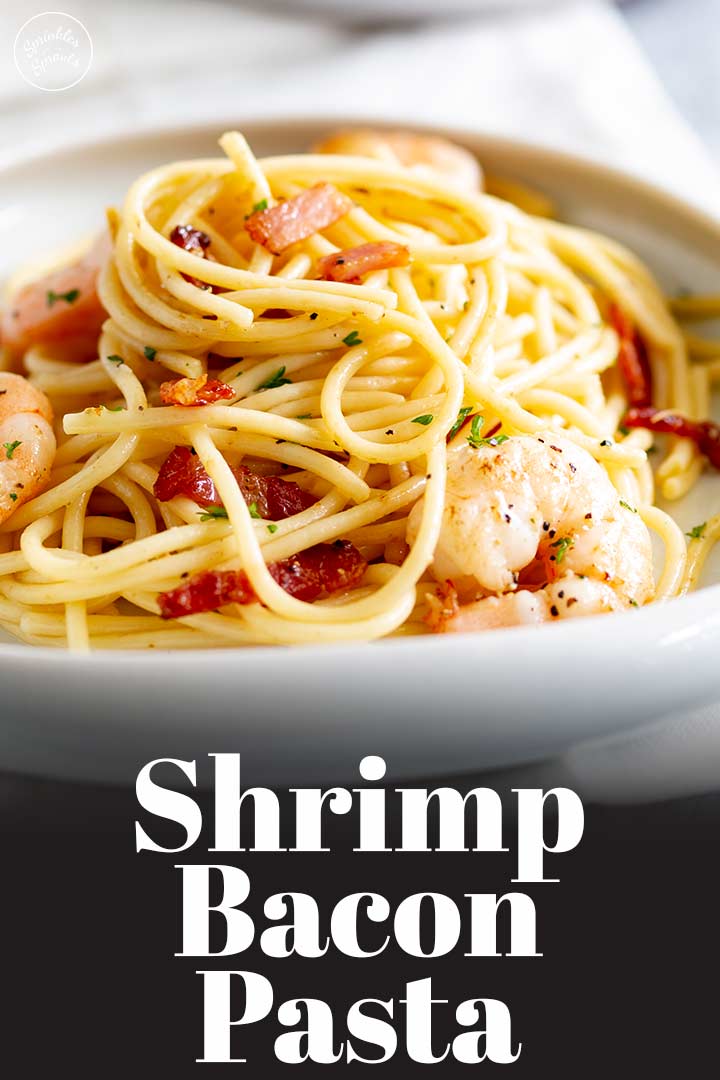 a white plate of pasta with shrimp on top and text at the bottom