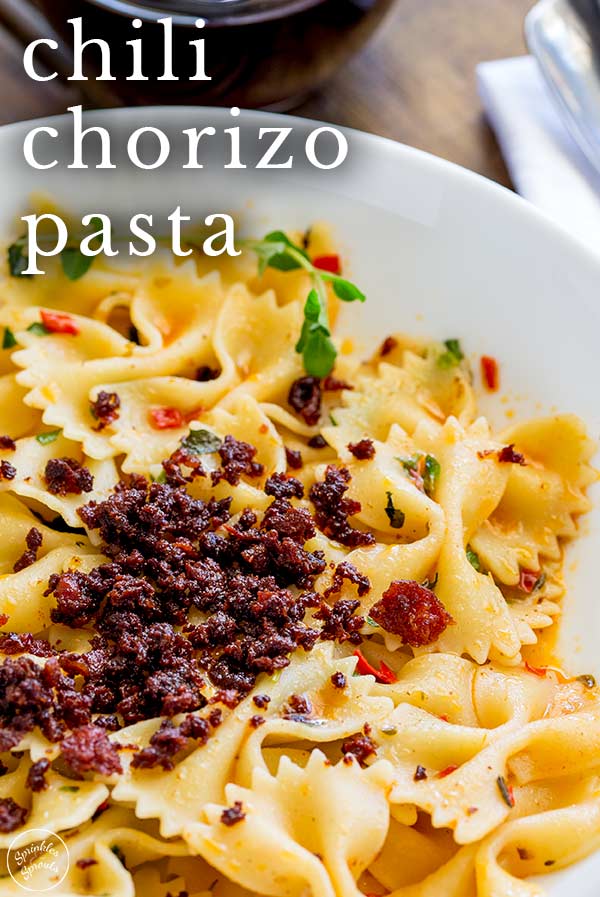 close up on the crispy chorizo on pasta with text at the top