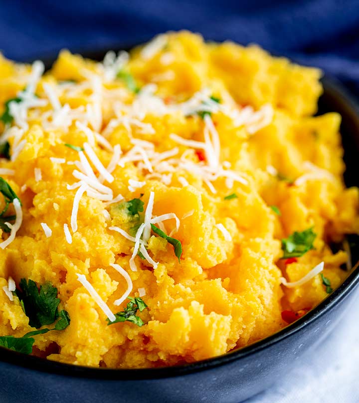 close up of sweet potato mash with shredded coconut and cilantro on top