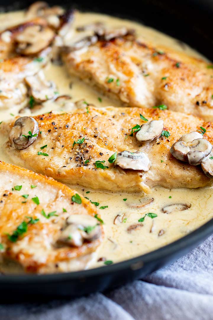 4 chicken fillets in a pan of creamy sauce