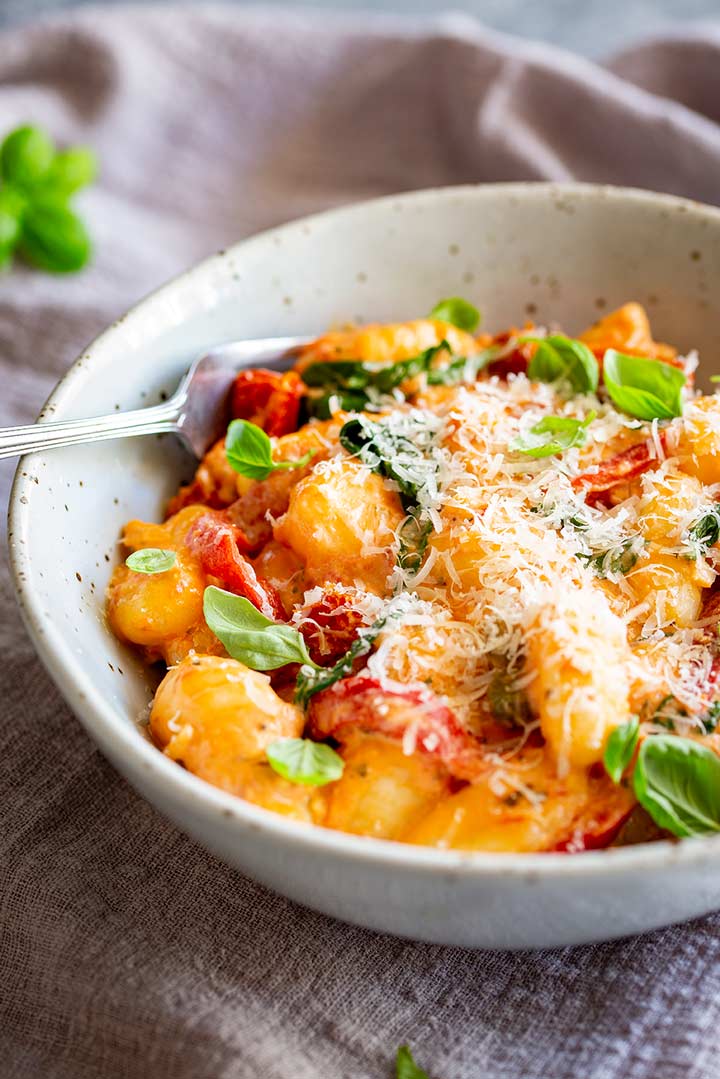 a silver fork dipping into a rustic bowl of the gnocchi