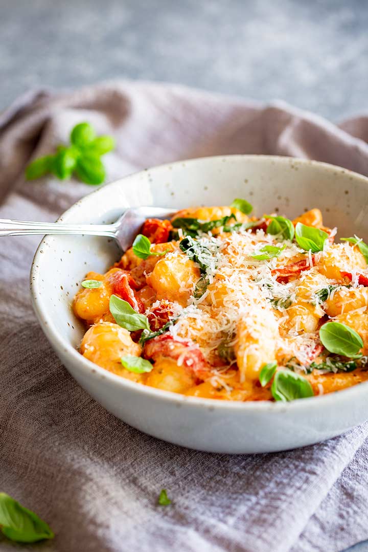a rustic bowl of the gnocchi sat on a linen napkin