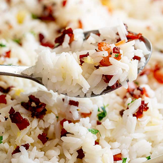 close up on a spoonful of rice with bacon sprinkled over