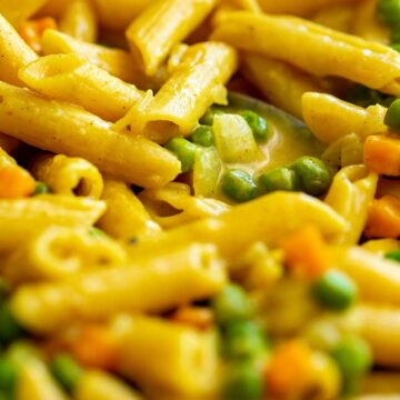 close up of curried penne pasta with peas