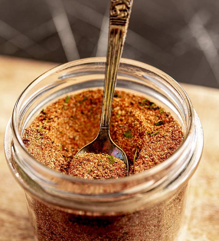 an ornate spoon in a jar of spice blend