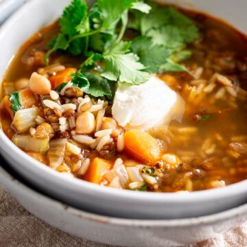 close up on a lentil soup with sour cream and cilantro garnish