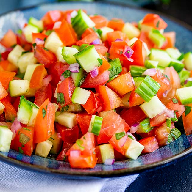 close up on the chopped cucumber and tomato in the Indian salad