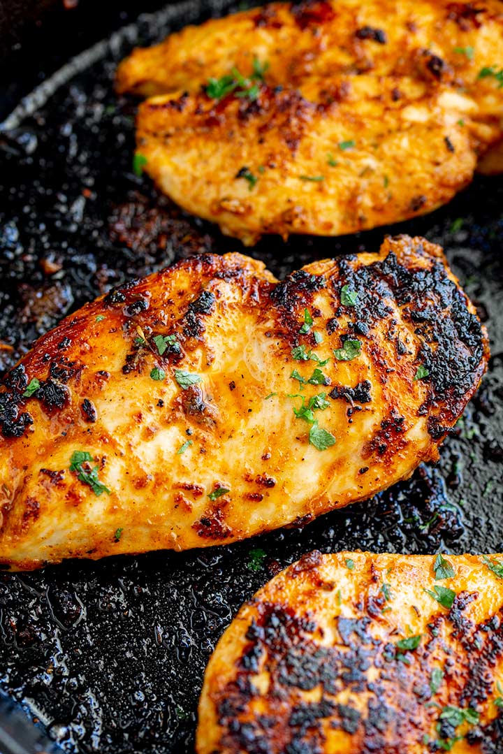 a charred chicken breast in a cast iron pan