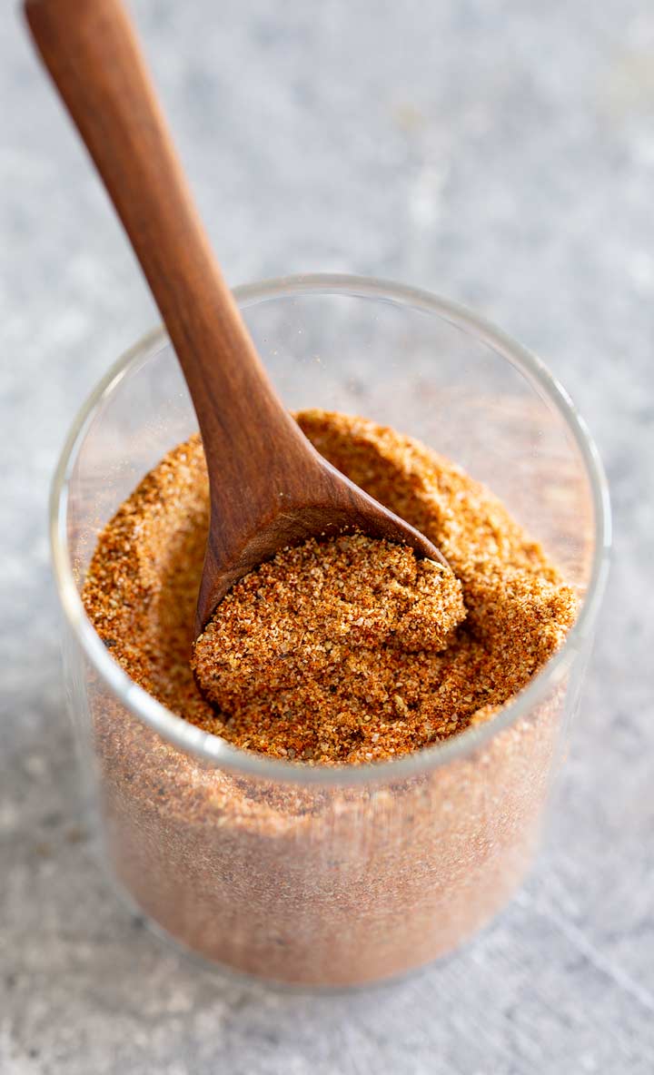 overhead picture of an open jar of seasoning with a spoon in it