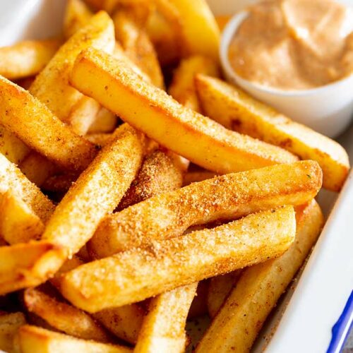 a close up on peri peri fries showing the seasoning on them