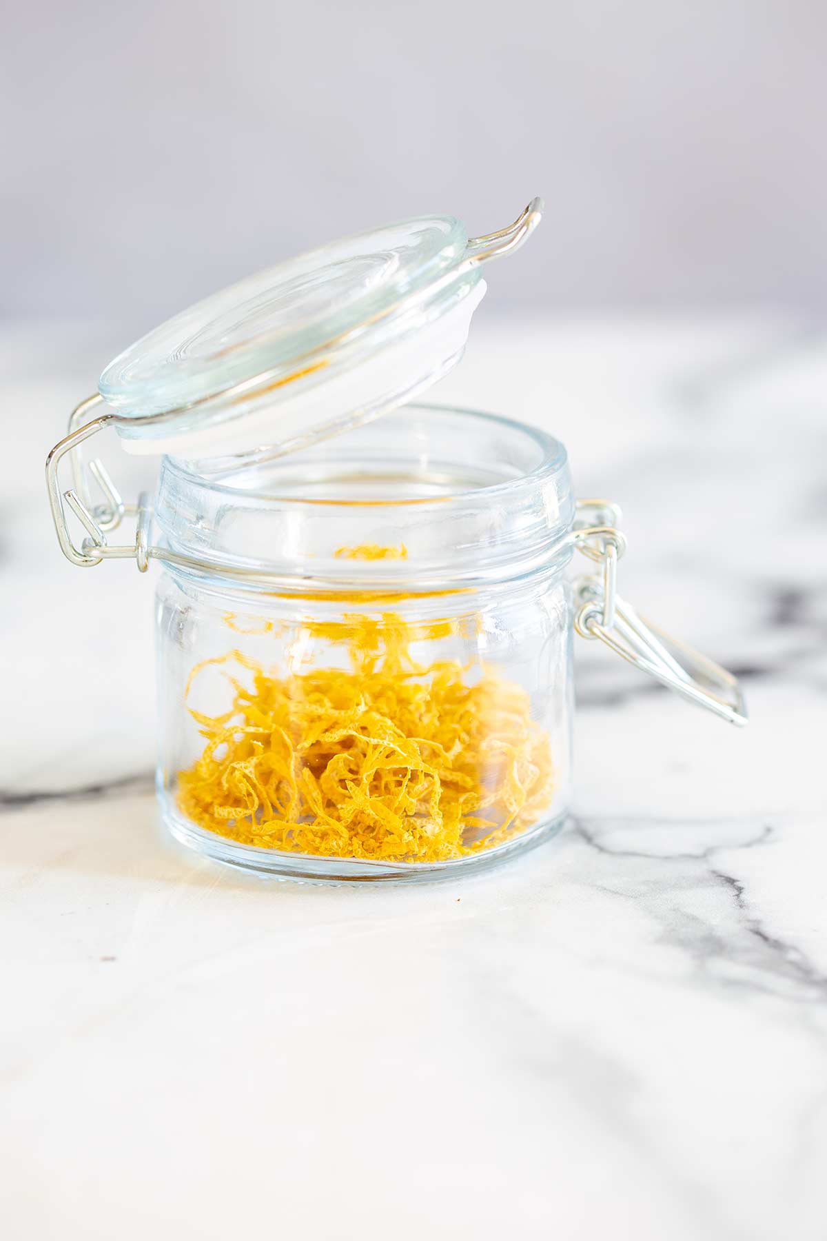 a small glass jar filled with dried lemon zest