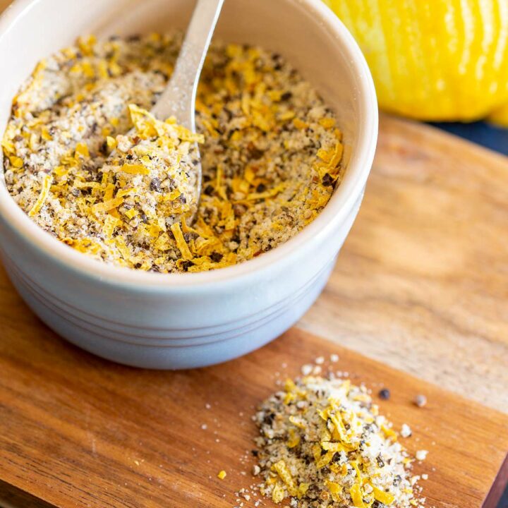 a spoon in a bowl of lemon pepper seasoning