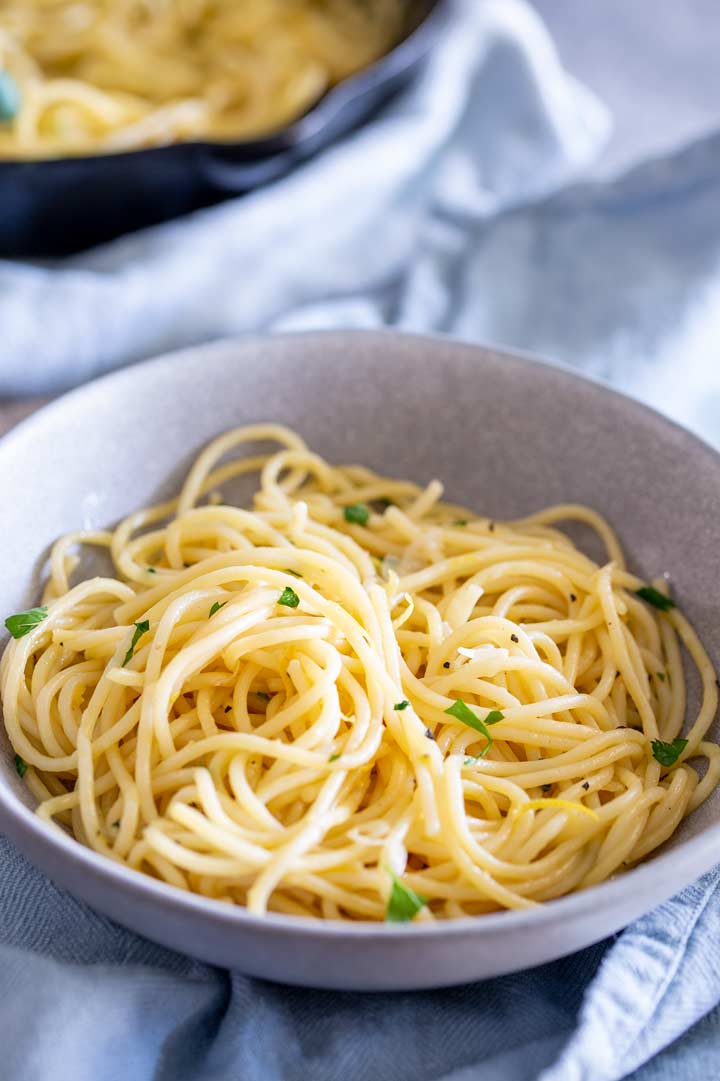 a grey bowl of pasta on a light blue napkin