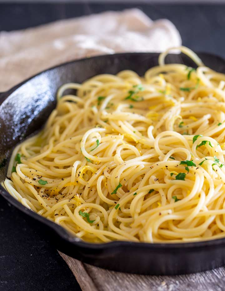 a black skillet of lemon and garlic pasta