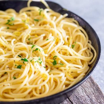 spaghetti with lemon and parsley in a black pan
