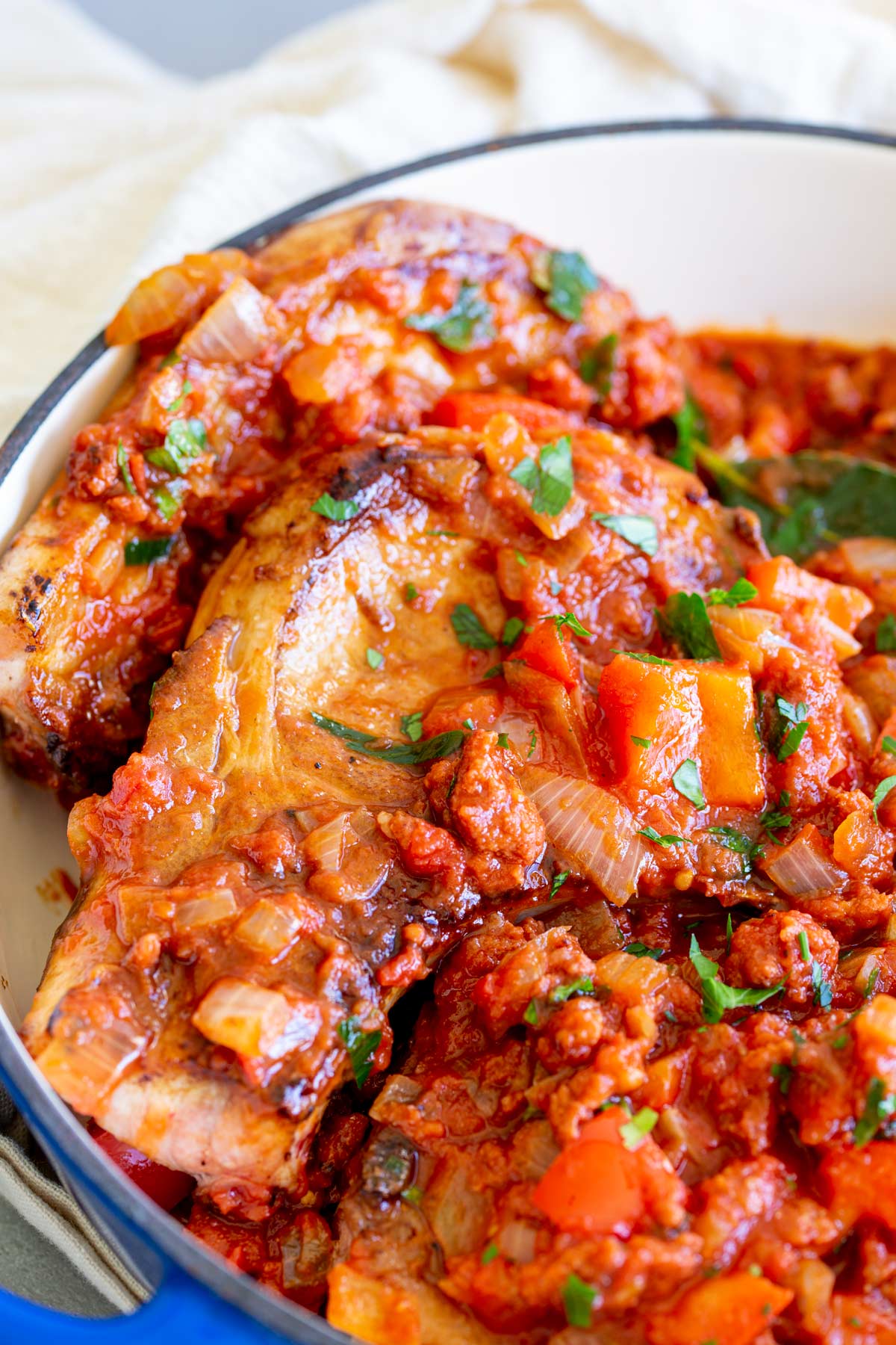 pork chops in a pan with a tomato sauce on top