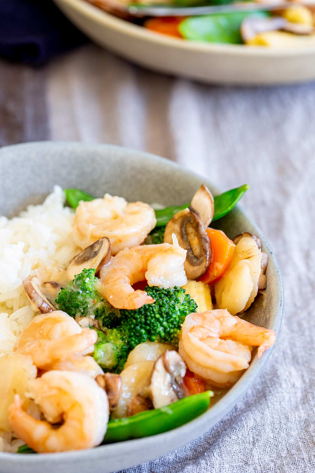 a grey bowl filled with shrimp, vegetables and rice