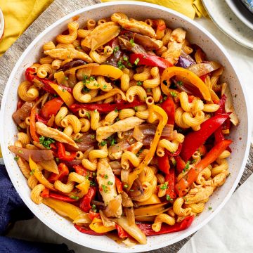 cavatappi with chicken peppers and fajita spices in a white bowl