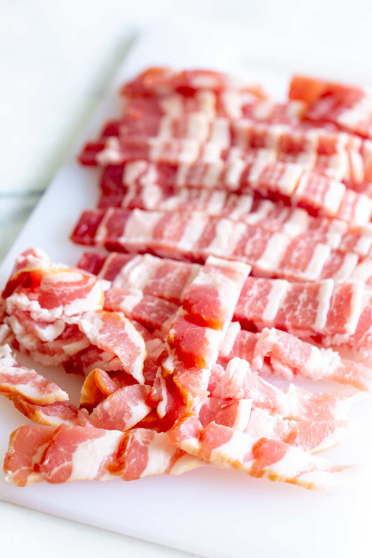 chopped bacon strips on a white board