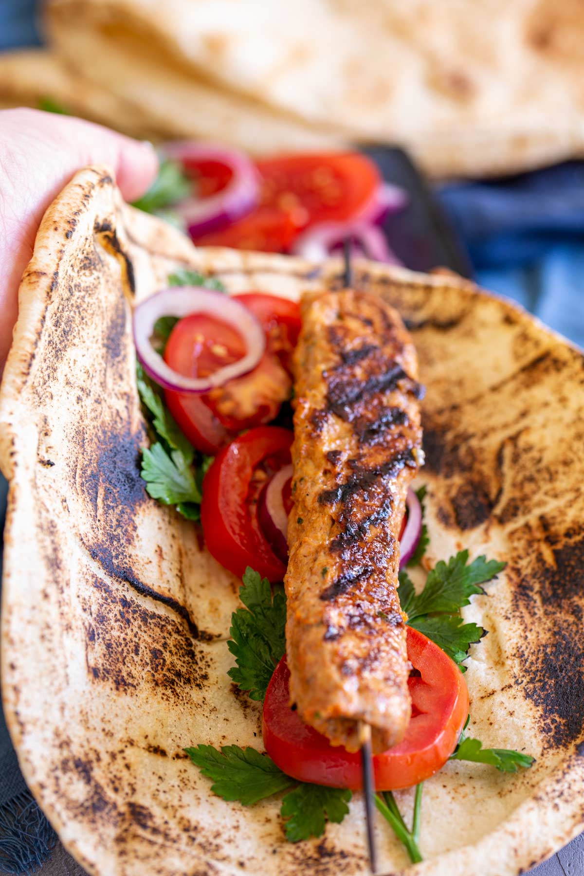 a chicken Adana Kebab in a flat bread with salad