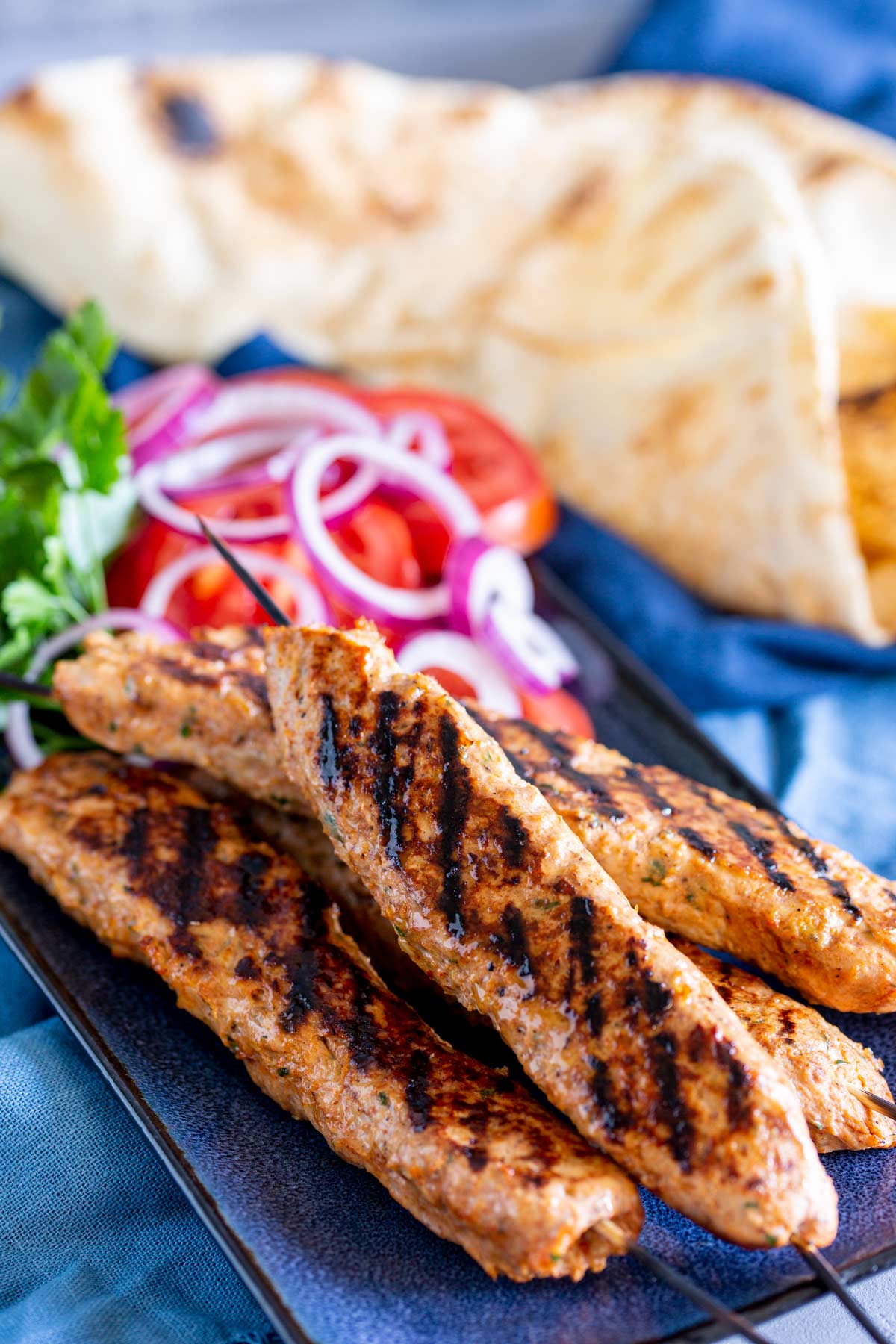 Chicken Kebabs on a blue plate with salad