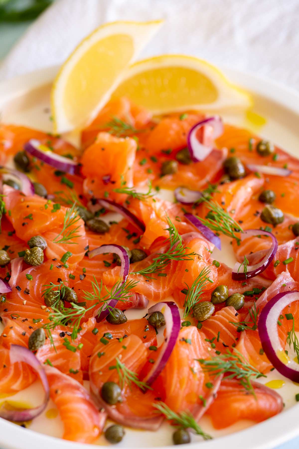 close up on raw salmon slices with onion and capers