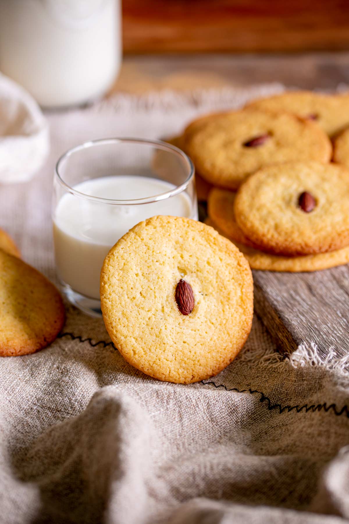 a cookie leaning against a glass of milk