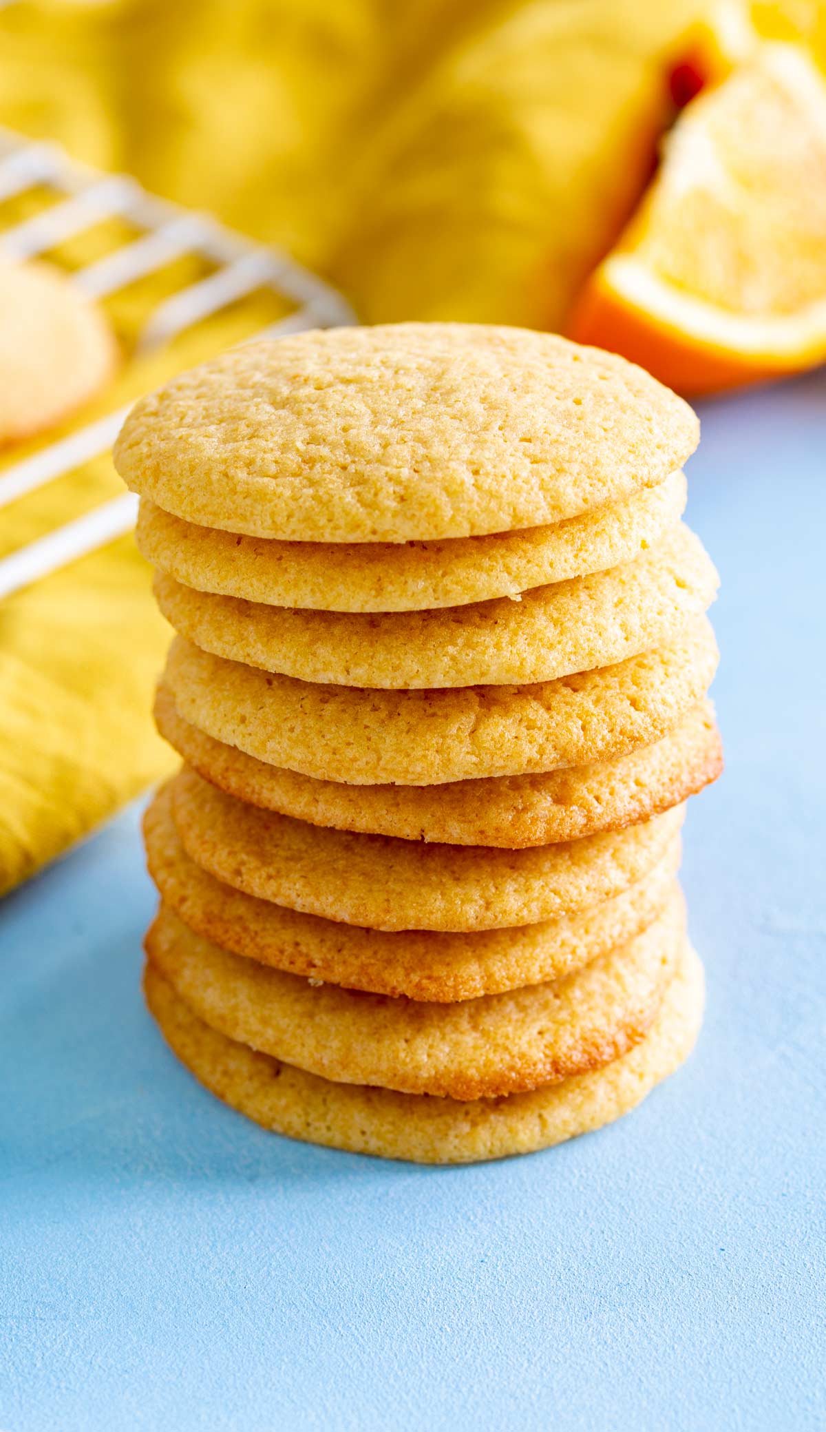 a tall stack of cookies on a blue table with orange segments behind