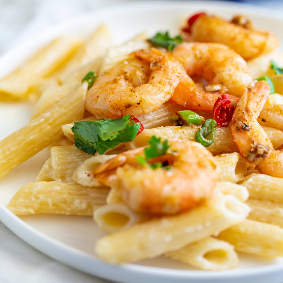 close up on some cajun shrimp on a plate of pasta