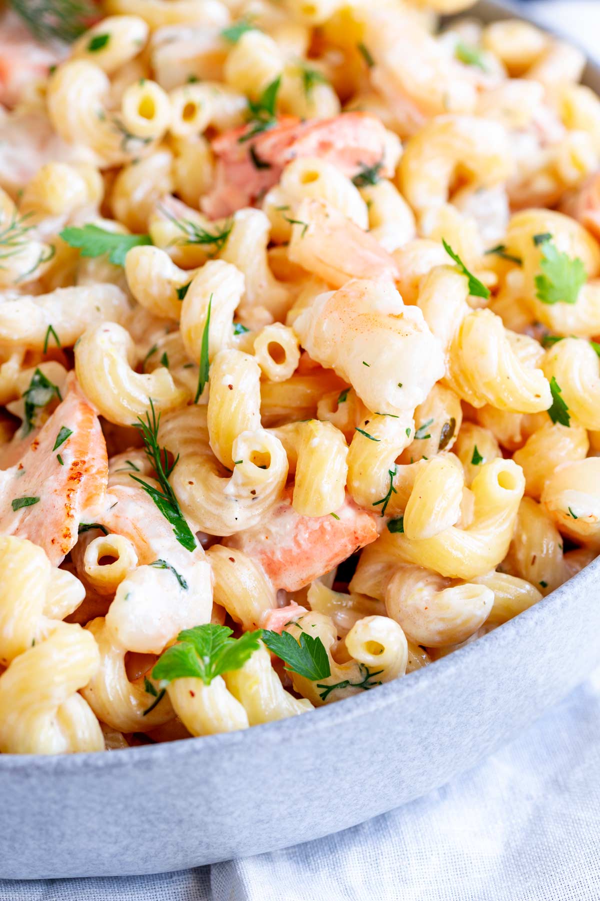 close up on a grey serving bowl of salmon and shrimp pasta