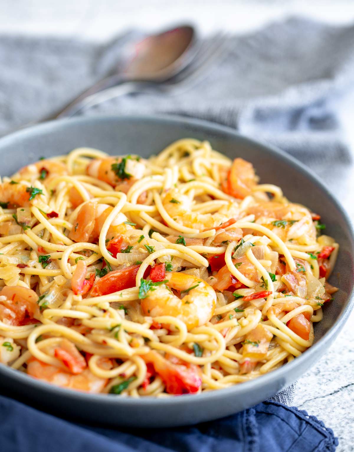 shrimp and tomato pasta in a grey bowl