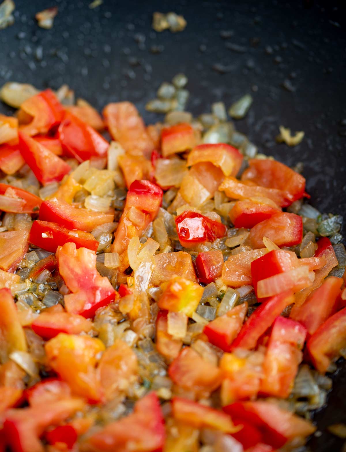 tomatoes and onion cooking in a pan