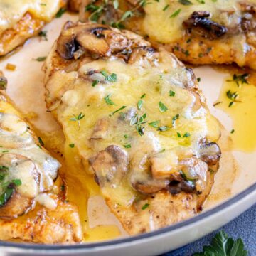 close upon a chicken breast topped with mushrooms and cheese