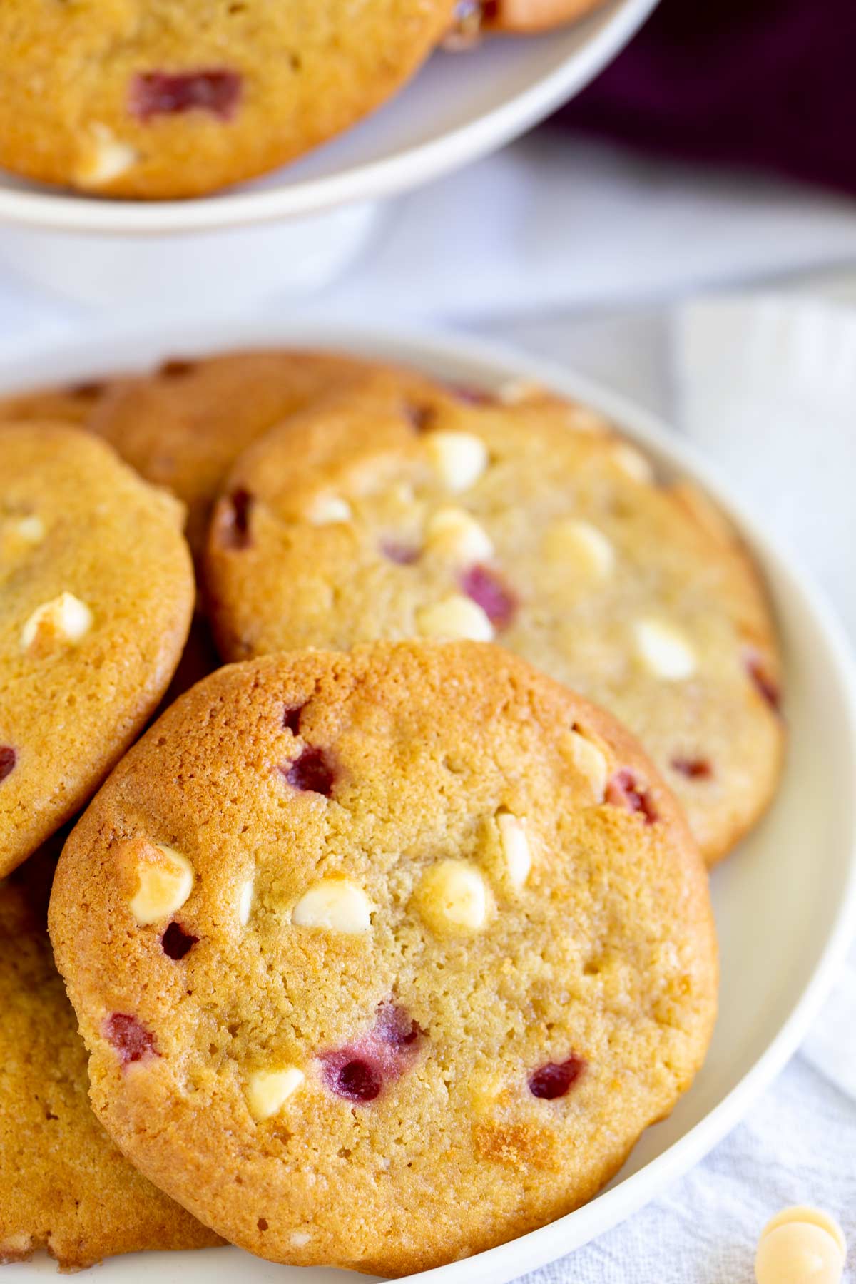 close up on one cookie in a pile, showing the choice chips and pockets of raspberry