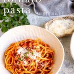 Pin image: A bowl of tomato bacon pasta on a table with text overlaid