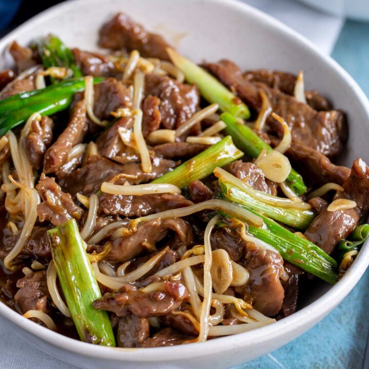 close up on a garlic beef stir fry in a white bowl