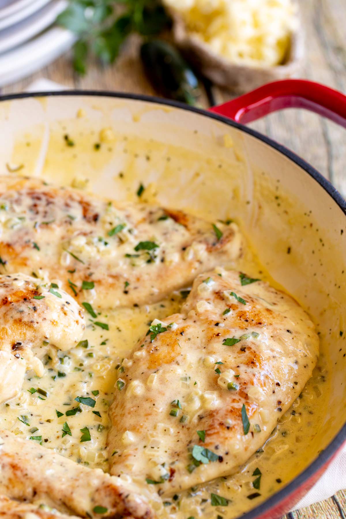 a chicken breast covered in creamy jalapeño sauce in a skillet