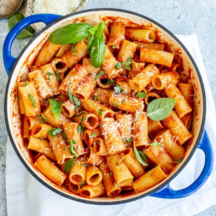 overhead view of rigatoni in tomato sauce in a blue cast iron pan