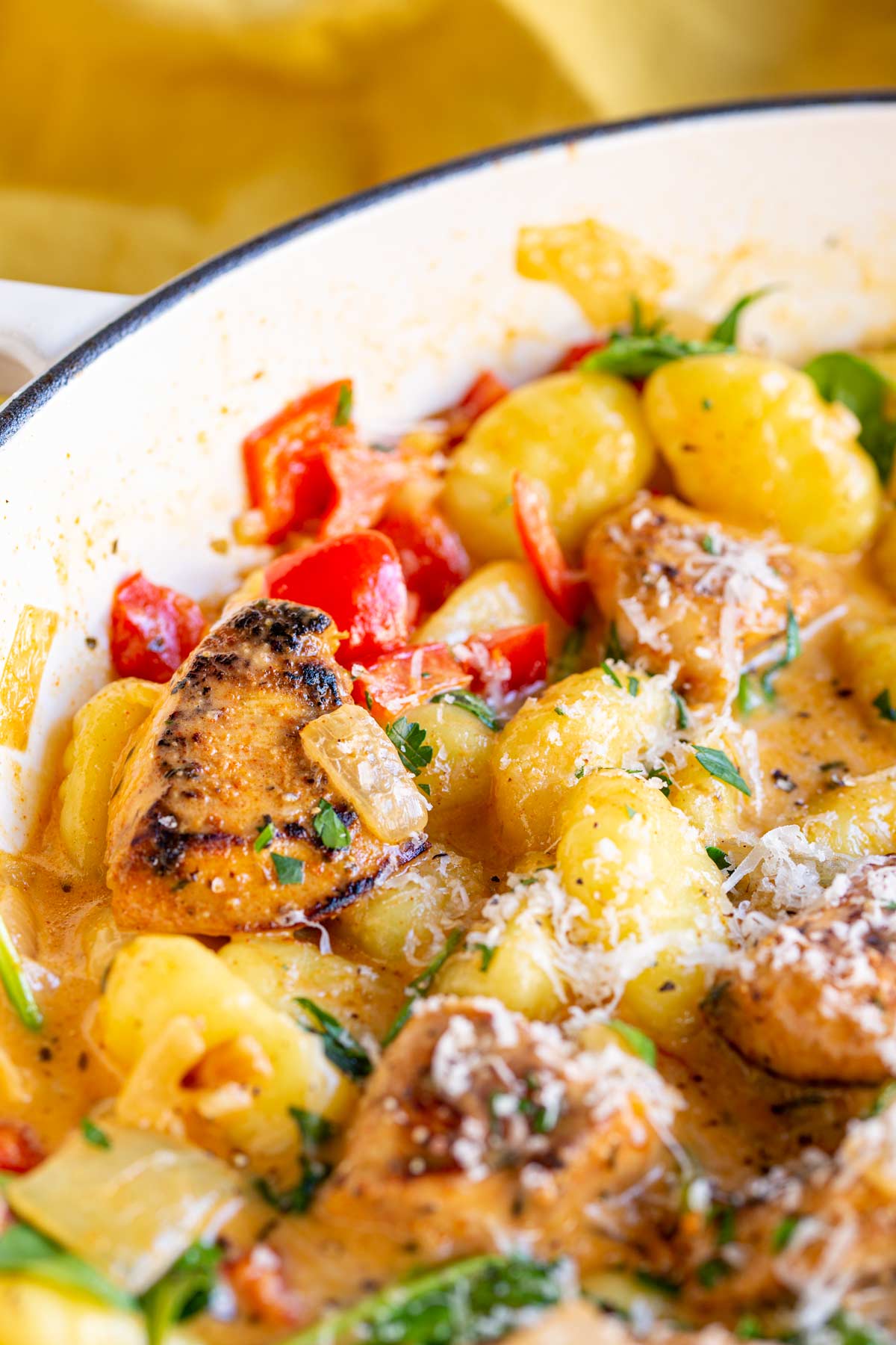close up on a piece of cajun chicken in a pan with some creamy gnocchi