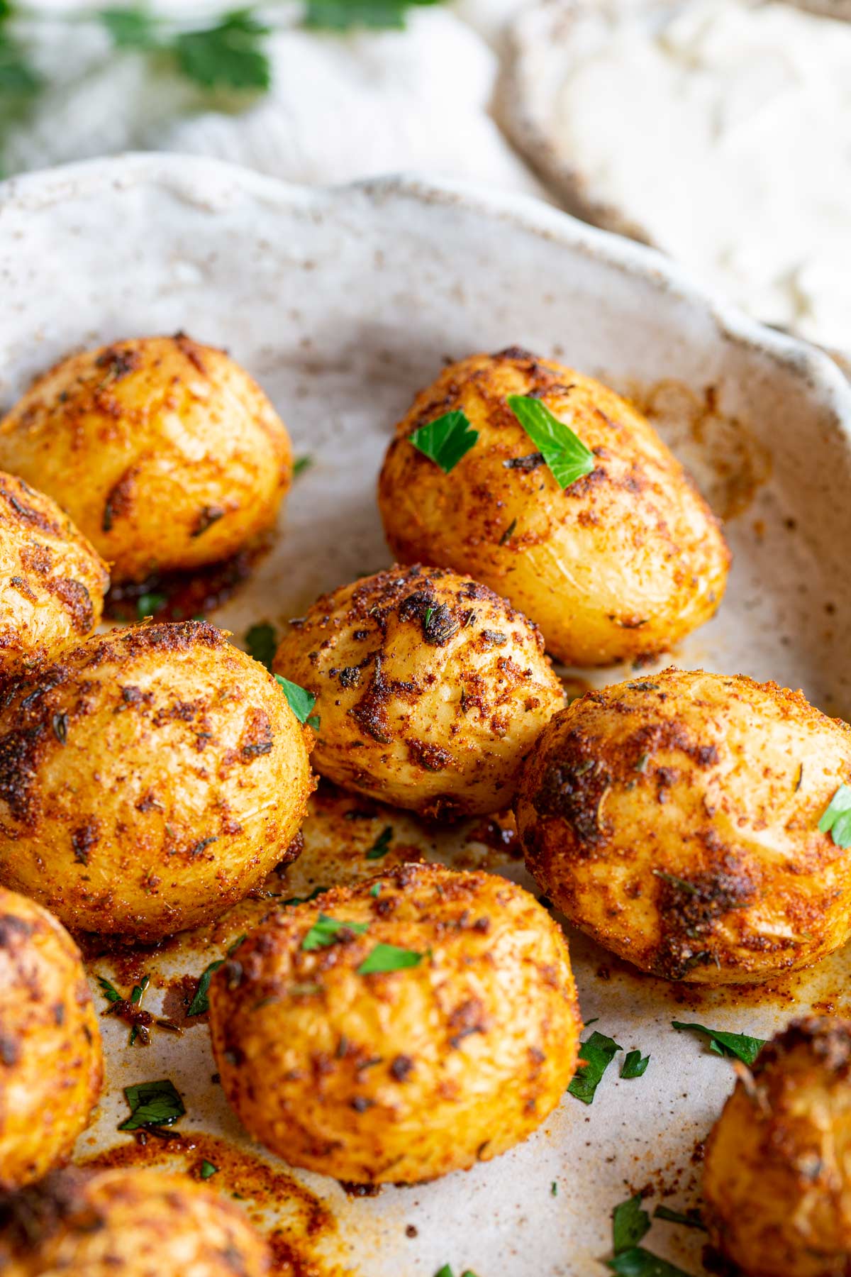 a pile of cajun spiced potatoes in a rustic roasting dish