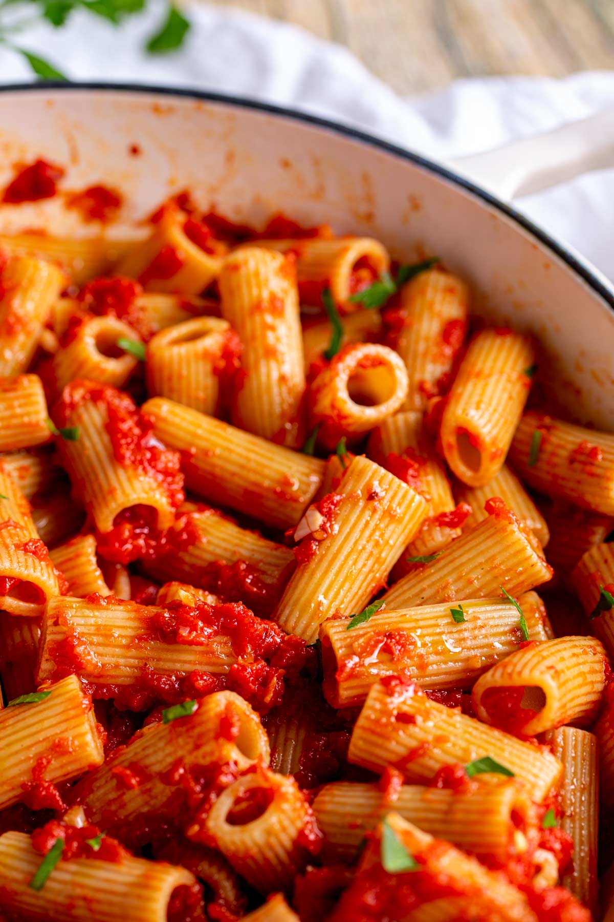 close up on how the sauce coats the pasta in the pan
