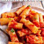 pin image: Rigatoni Arrabbiata on a rustic plate with text overlaid