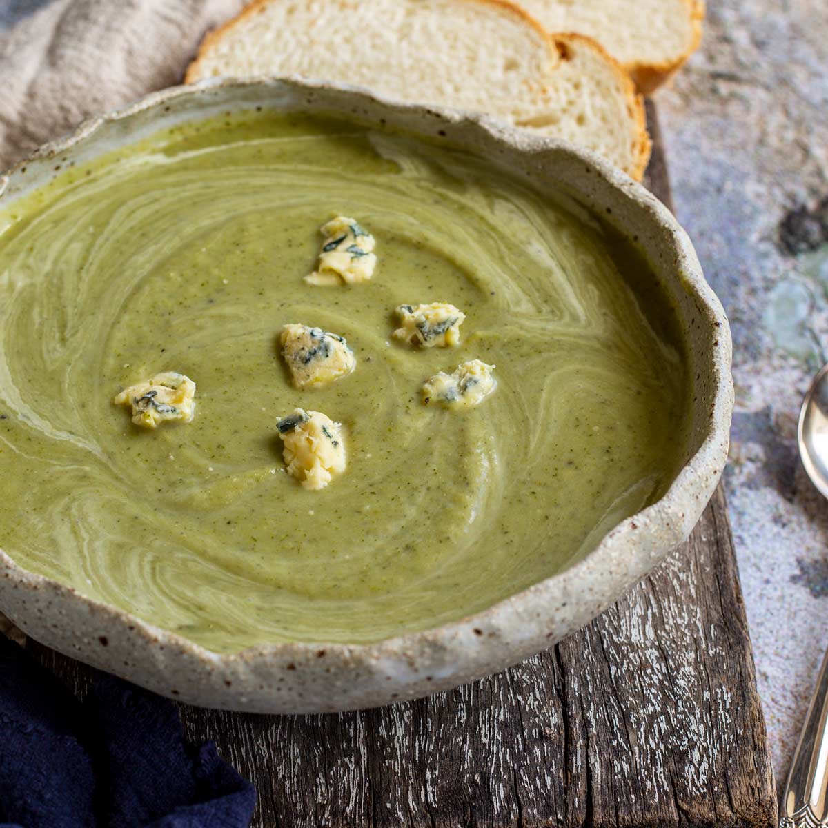 close up on a rustic bowl of broccoli and blue cheese soup