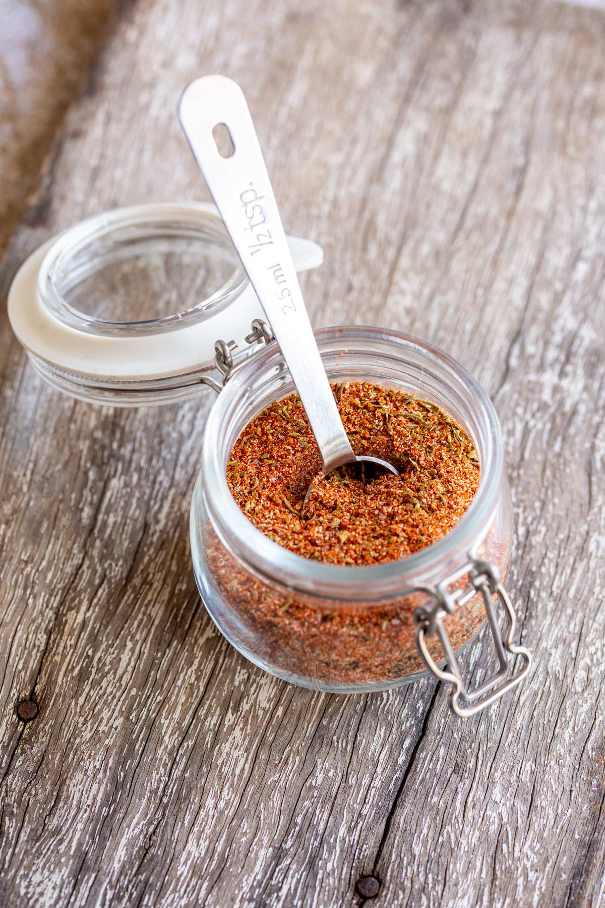 a metal ½ teaspoon sticking out of a glass jar of cajun seasoning blend