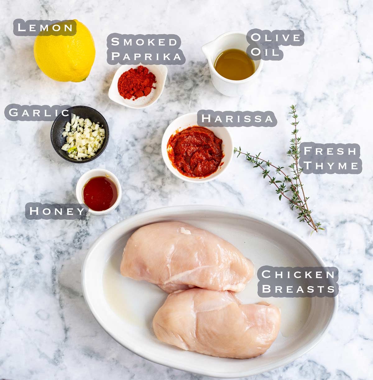 ingredients to make harissa honey chicken slayed out on a marble bench